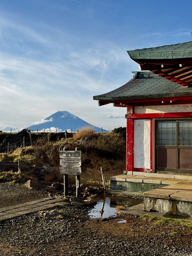 A red shrine building with Mt. Fuji in the distance at Hakone