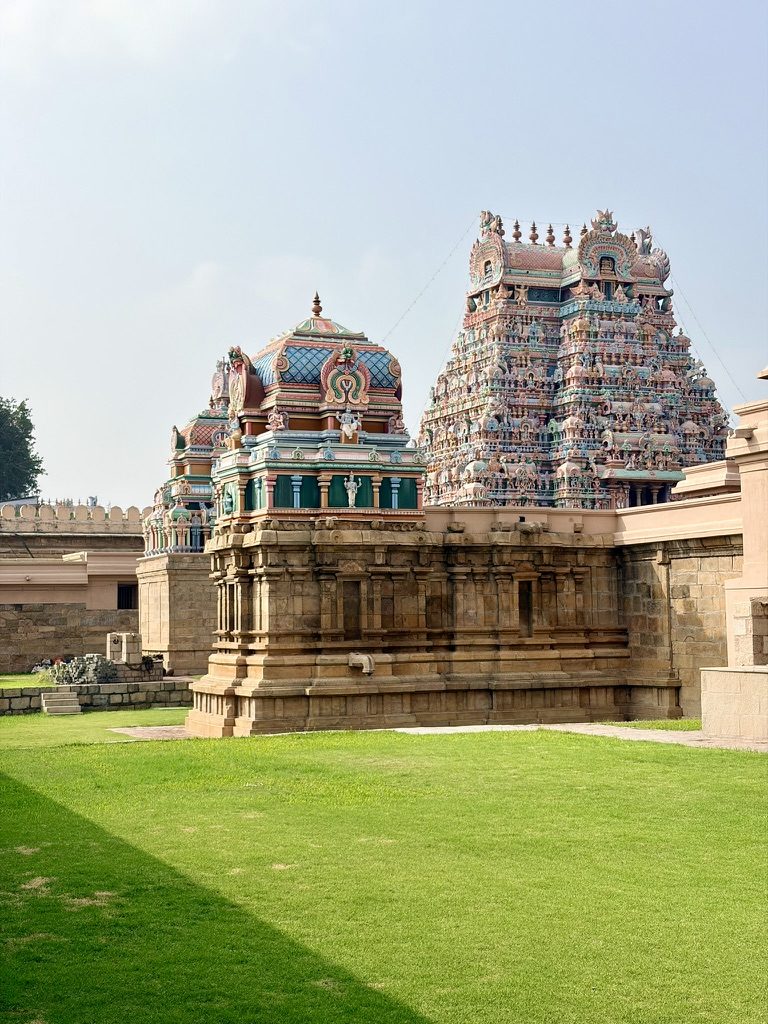 Colourful gopurams of a temple in Srirangam above a green lawn